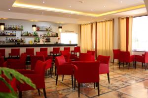 a restaurant with red chairs and a bar at Zodiaco in Quarteira