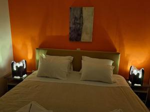 a bedroom with a bed with an orange wall at Mary's Home Center City F in Aigio