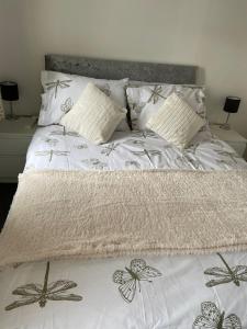 Una cama con un edredón blanco con mariposas. en Homely property close to Princess Royal hospital and Apley Wood en Wellington