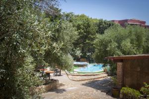 トッレ・デイ・コルサリにあるHotel Villa Belfioriのスイミングプールと木々のあるリゾート