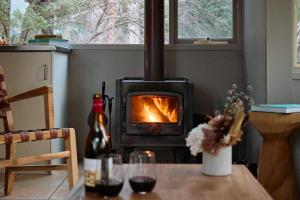 a stove in a living room with a table with a fireplace at Aquila Eco Lodges in Dunkeld