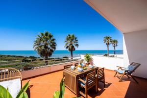 a patio with a table and chairs and the ocean at Big Wave Front Row - Two Bedroom in Nazaré