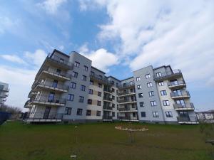 zwei hohe Apartmenthäuser auf einem Rasenplatz in der Unterkunft DĘBOWA KUTNO in Kutno