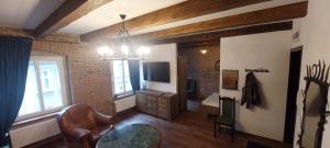 a living room with a television and a chair at Apartament loftowy in Świdnica