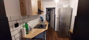 a kitchen with a sink and a refrigerator at Apartament loftowy in Świdnica