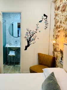a bedroom with a bathroom with a tree sticker on the wall at Soléa House Hotel Boutique in Benicàssim