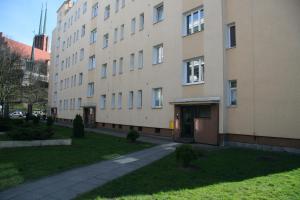 ein Apartmenthaus mit Bürgersteig neben einem Gebäude in der Unterkunft SmileApartment Partyzantów in Gdynia