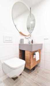 W łazience znajduje się biała toaleta i lustro. w obiekcie SOFI-LIVING-APARTMENTS w Hanowerze