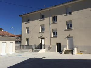 un gran edificio blanco con escaleras delante en Le Logis Dauphinois, en Roussillon en Isère