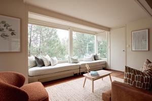 a living room with a couch and a large window at Aquila Eco Lodges in Dunkeld