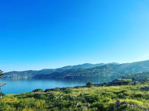 a view of a lake with mountains in the background at Perdika's Nest, family friendly house by the sea in Perdika