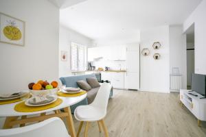 a white kitchen and living room with a table and chairs at La Casa di Lo near Vatican in Rome