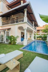 a villa with a swimming pool in front of a house at Elivaas Opalys Luxe 4BHK Villa with Pvt Pool near Baga in Calangute