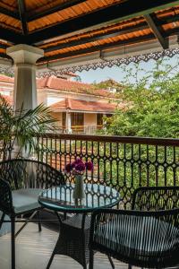 einen Tisch mit einer Blumenvase auf einer Terrasse in der Unterkunft Elivaas Opalys Luxe 4BHK Villa with Pvt Pool near Baga in Calangute