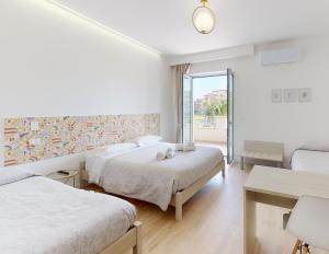 um quarto de hotel com duas camas e uma janela em Accòmodati B&B em Marina di Gioiosa Ionica