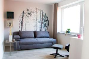 uma sala de estar com um sofá e uma cadeira em SOFI-LIVING-APARTMENTS em Hanôver