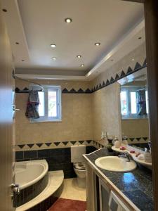 une salle de bain avec deux lavabos et une baignoire et des toilettes dans l'établissement Aleksandras Διαμερίσματα, à Ioannina 20 autres photos