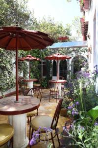 a patio area with tables, chairs and umbrellas at Boutique Hotel Antinea in Quito