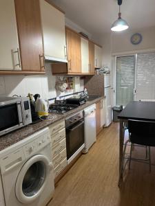 y cocina con lavadora y fogones. horno superior en Apartamento Albufeira,4 pessoas, com wi-fi e a 15m a pé da praia, en Albufeira