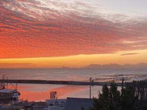 una puesta de sol sobre el océano con una playa en Saxon Lodge en Gansbaai