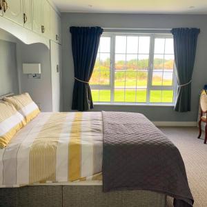 a bedroom with a bed and a large window at The Lake House Dungloe in Dungloe