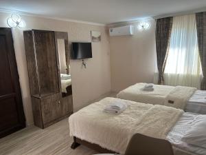 a hotel room with two beds and a television at Oldtown Apartments in Mtskheta