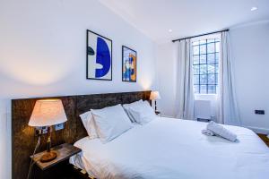 een slaapkamer met een groot bed en een raam bij Charming 1BR Apartment in a gated complex and a short walk from Queens Park Tube in Londen