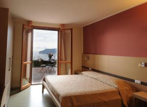a bedroom with a bed and a door to a balcony at Oroverde in Bergeggi