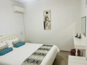 a white bedroom with a large bed and a picture on the wall at Riverside Suite in Kalopanayiotis
