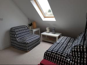 um quarto com uma cama, uma cadeira e uma janela em 1 bed apartment in West London em Heston