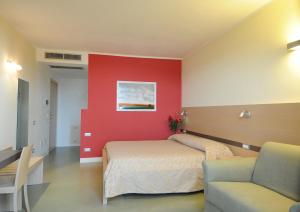 a bedroom with a bed and a red wall at Oroverde in Bergeggi