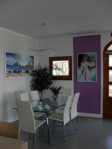 a dining room with a glass table and white chairs at Oroverde in Bergeggi