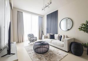 uma sala de estar com um sofá branco e um espelho em Nasma Luxury Stays - Harbour Gate Tower 1 em Dubai