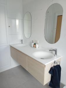 bagno bianco con lavandino e specchio di Boyle's Beach House - Fully furnished 3 Bedroom home. Secure parking. a Nambucca Heads