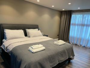 a bedroom with a bed with two towels on it at Modern and spacious, family house. in Luton