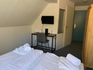 a hotel room with two beds and a desk at Landhotel Cafe Prälank in Neustrelitz
