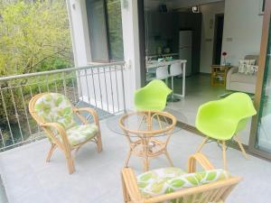 drie stoelen en een tafel op een balkon bij Riverside Suite in Kalopanayiotis