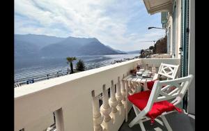 a balcony with a table and chairs and a view of the ocean at Larius Apartment Carate Urio in Laglio
