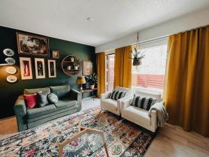 a living room with two couches and a window at Pieni lomahuoneisto ja ulkoporeallas in Mynämäki