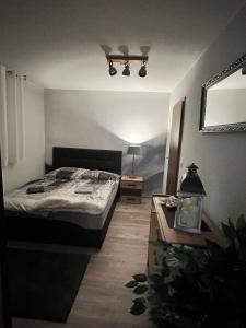 1 dormitorio con 1 cama y 1 mesa con lámpara en Souterrainwohnung im Speckgürtel von Erfurt! en Großrudestedt