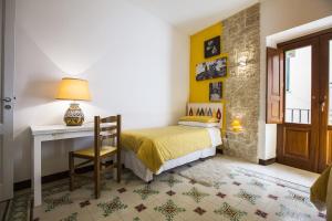 a bedroom with a bed and a desk with a lamp at Antico Borgo in Erice