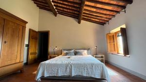 Un dormitorio con una cama grande en una habitación con techos de madera. en Masseria di Matraia, en Matraia
