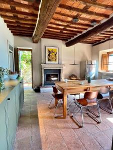 cocina con mesa, sillas y chimenea en Masseria di Matraia, en Matraia