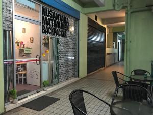 a restaurant with a table and chairs in front of a window at Nusantara Mattwaddien Hostel in Kota Kinabalu