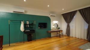 una camera con parete verde, scrivania e specchio di Kimberley Boutique Hotel a George Town