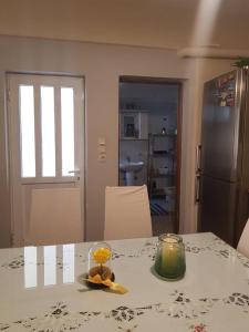 a kitchen with a table with a glass bowl of fruit and a candle at The Quiet Corner in Kalamata