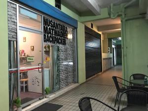 a restaurant with a sign on the window and a table at Nusantara Mattwaddien Hostel in Kota Kinabalu