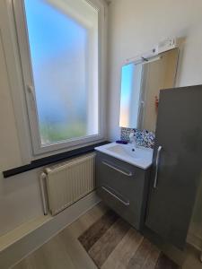 ein Bad mit einem Waschbecken und einem Fenster in der Unterkunft La ScarpeHouse - Douai - Wifi in Douai