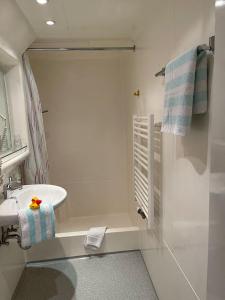 uma casa de banho branca com um lavatório e um espelho em A&S Ferienzentrum Oberhof em Oberhof