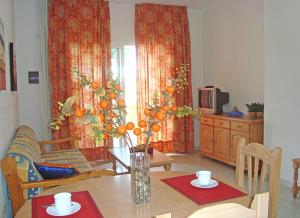 una sala de estar con una mesa con naranjas. en APCOSTAS - Complejo Al Andalus, en Alcossebre